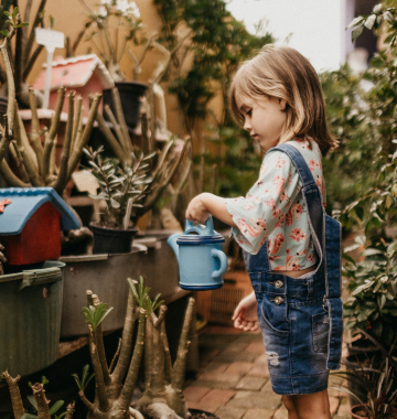 Girl with a watering can in the garden